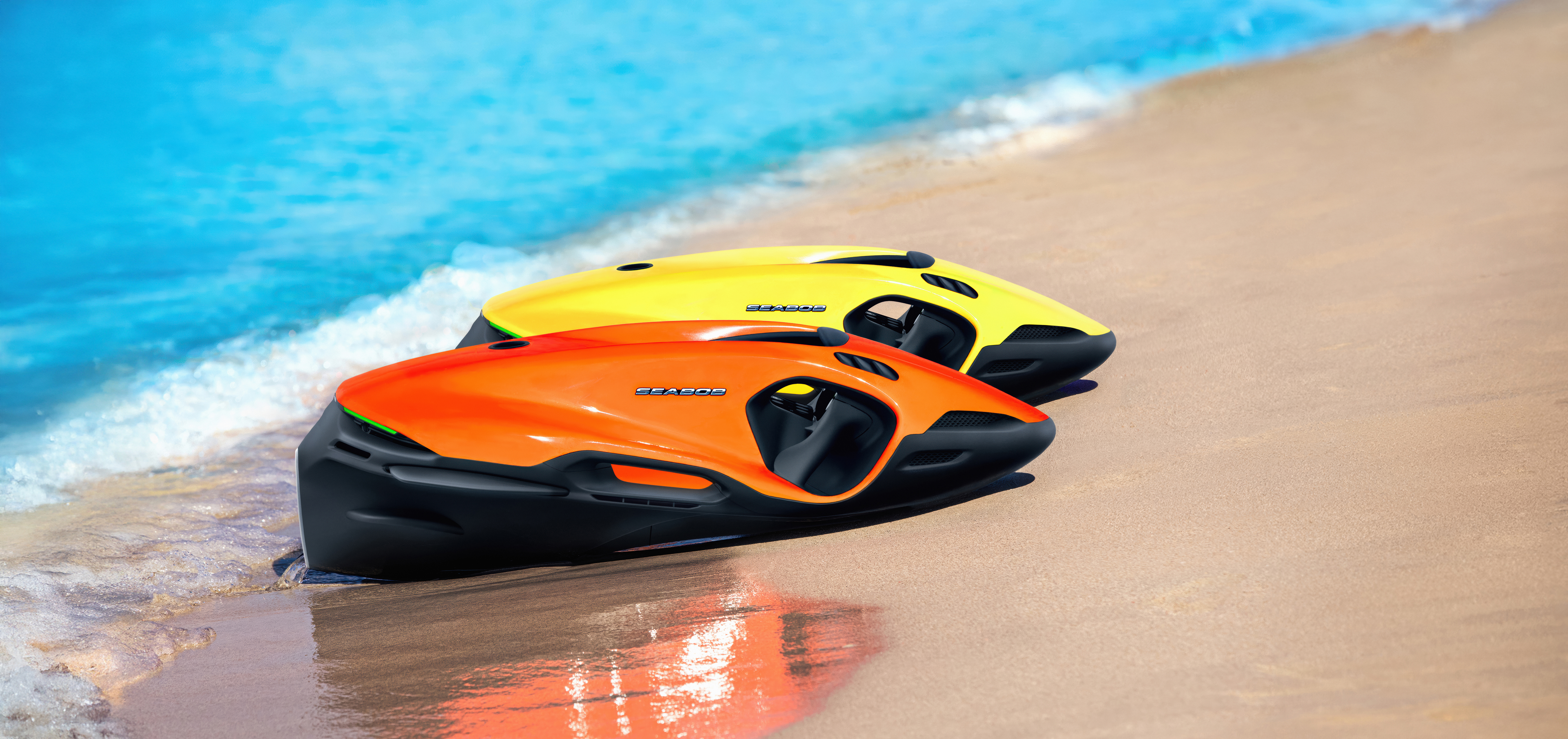 Orange and yellow SEABOB F9 underwater jets resting on a tropical beach